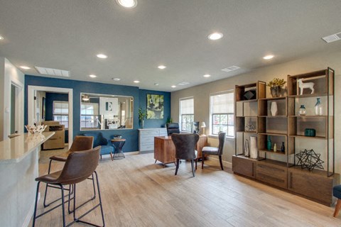 a living room with chairs and a bar and a kitchen